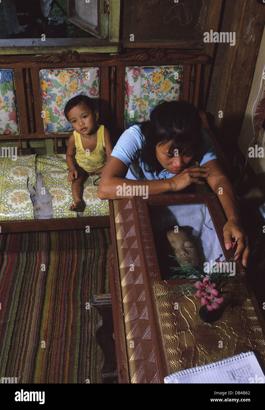 Filipinos rural pobre madre llora a su hijo de cuatro años de edad en 1985, quien murió en un hospital del gobierno debido a la falsa medicina. Foto de stock