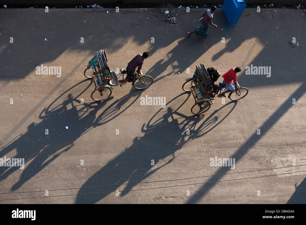 Vista desde arriba de rickshaws proyecten sombras en la calle, ya que el ferry de pasajeros a lo largo de las calles de Chittagong, Bangladesh Foto de stock