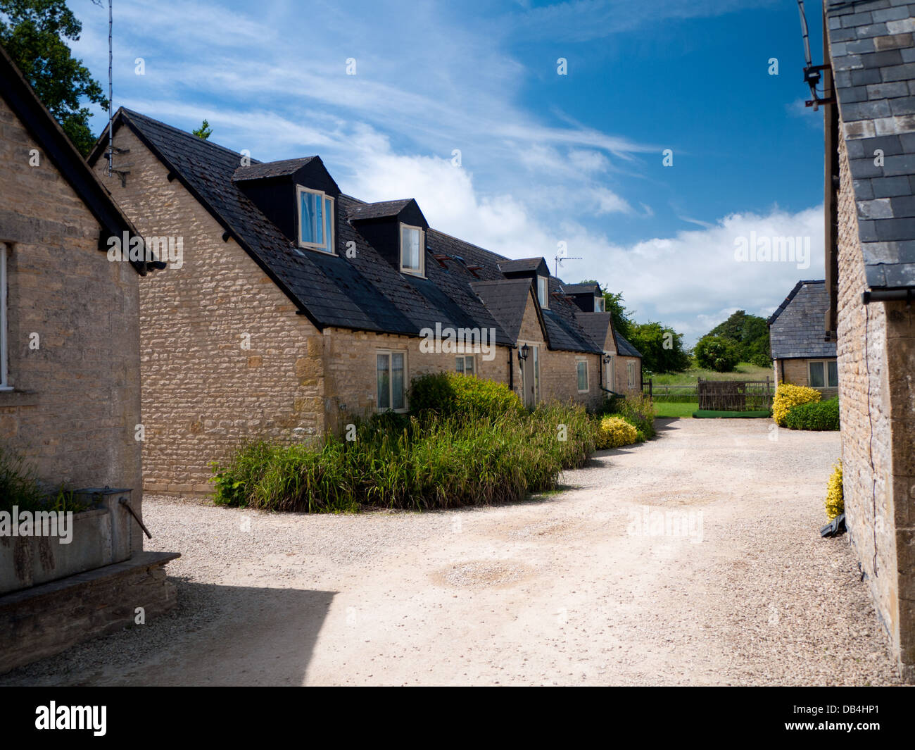 Los tradicionales edificios de piedra que componen la losa Farm holiday cottages, estibar en la Wold, Cotswolds, Inglaterra, Reino Unido. Foto de stock