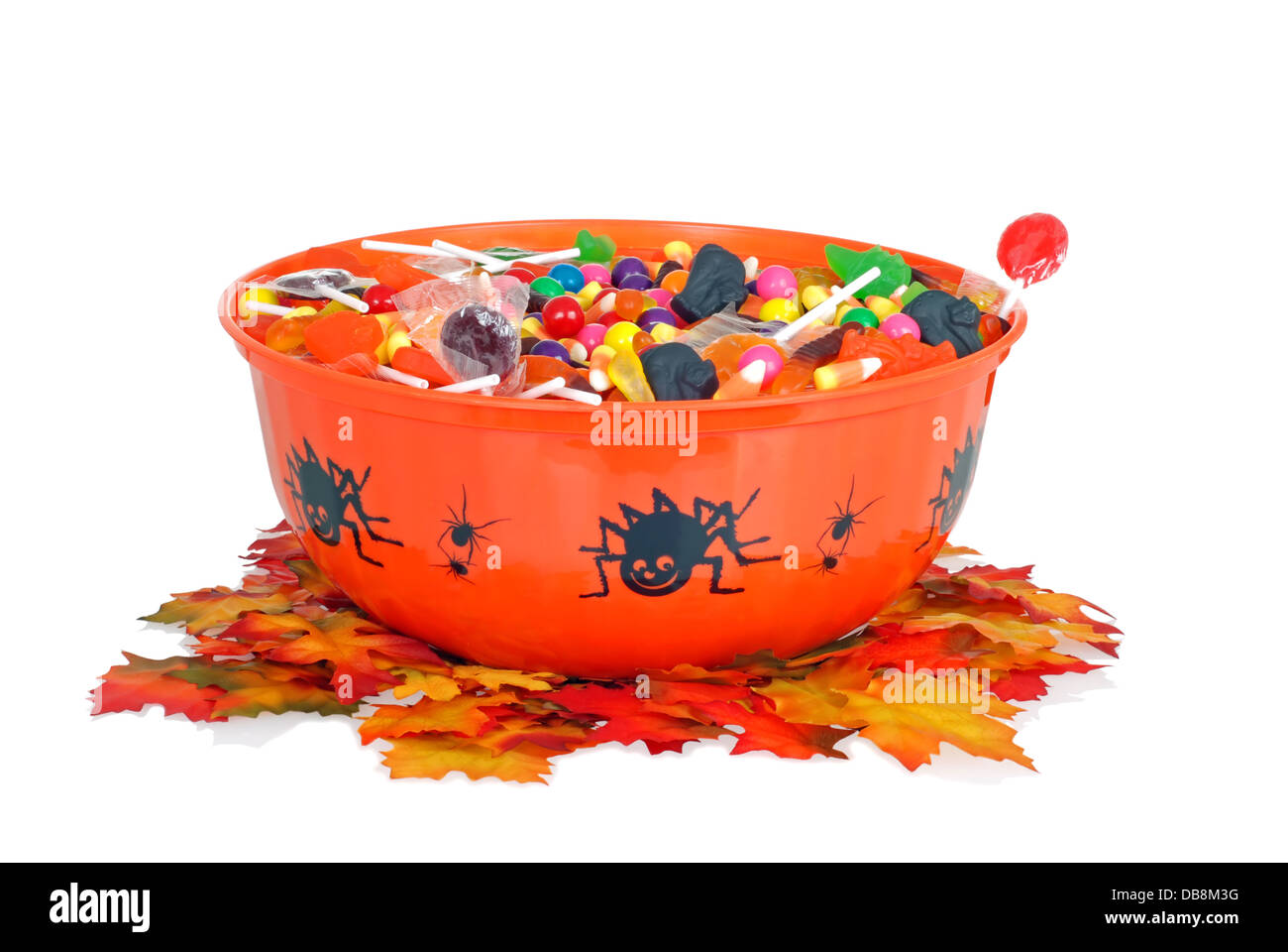 Golosinas de Halloween en un recipiente con hojas caer Foto de stock