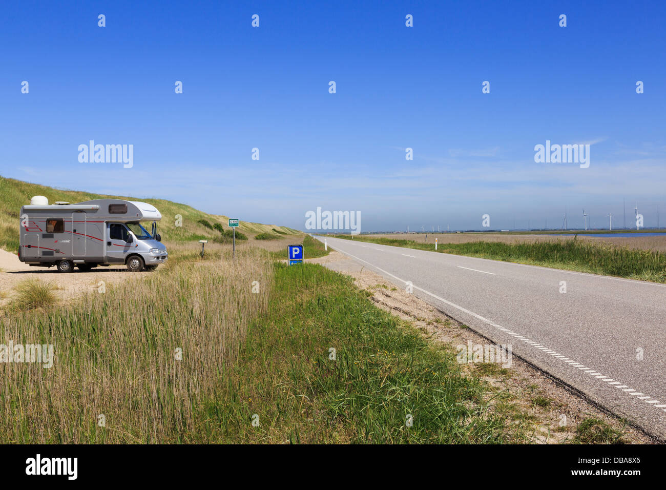 Autocaravana aparcada por una duna de arena junto a la carretera de la costa 181 sobre Bovling Klit istmo con vistas Bovling Fjord en el oeste de Jutlandia, Dinamarca Foto de stock