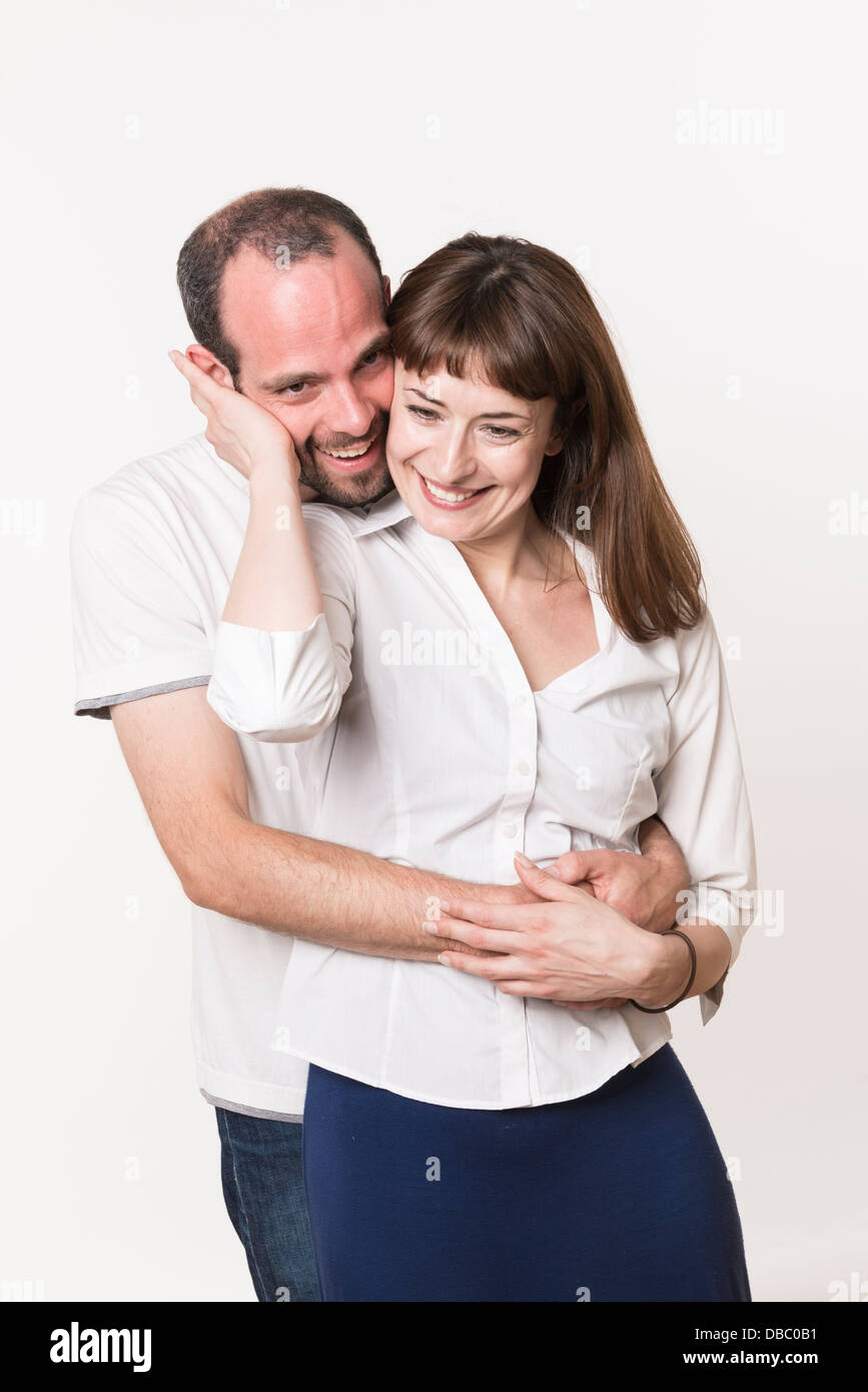 Adulto joven pareja caucásica felices juntos, el hombre abrazando a la mujer desde atrás Foto de stock