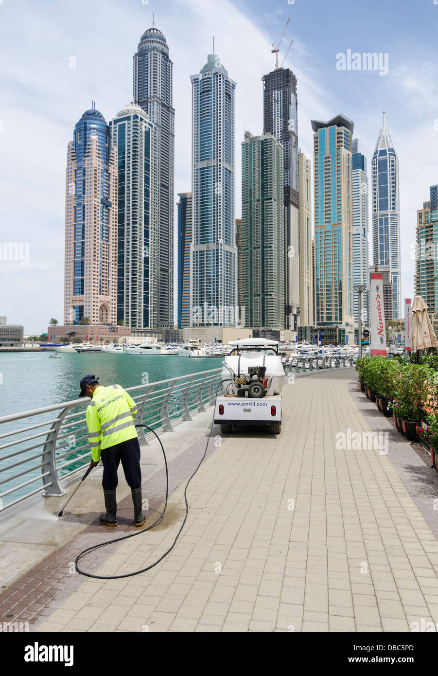 El hombre la limpieza del paseo marítimo, el puerto deportivo de Dubai, Dubai, Emiratos Árabes Unidos. Foto de stock