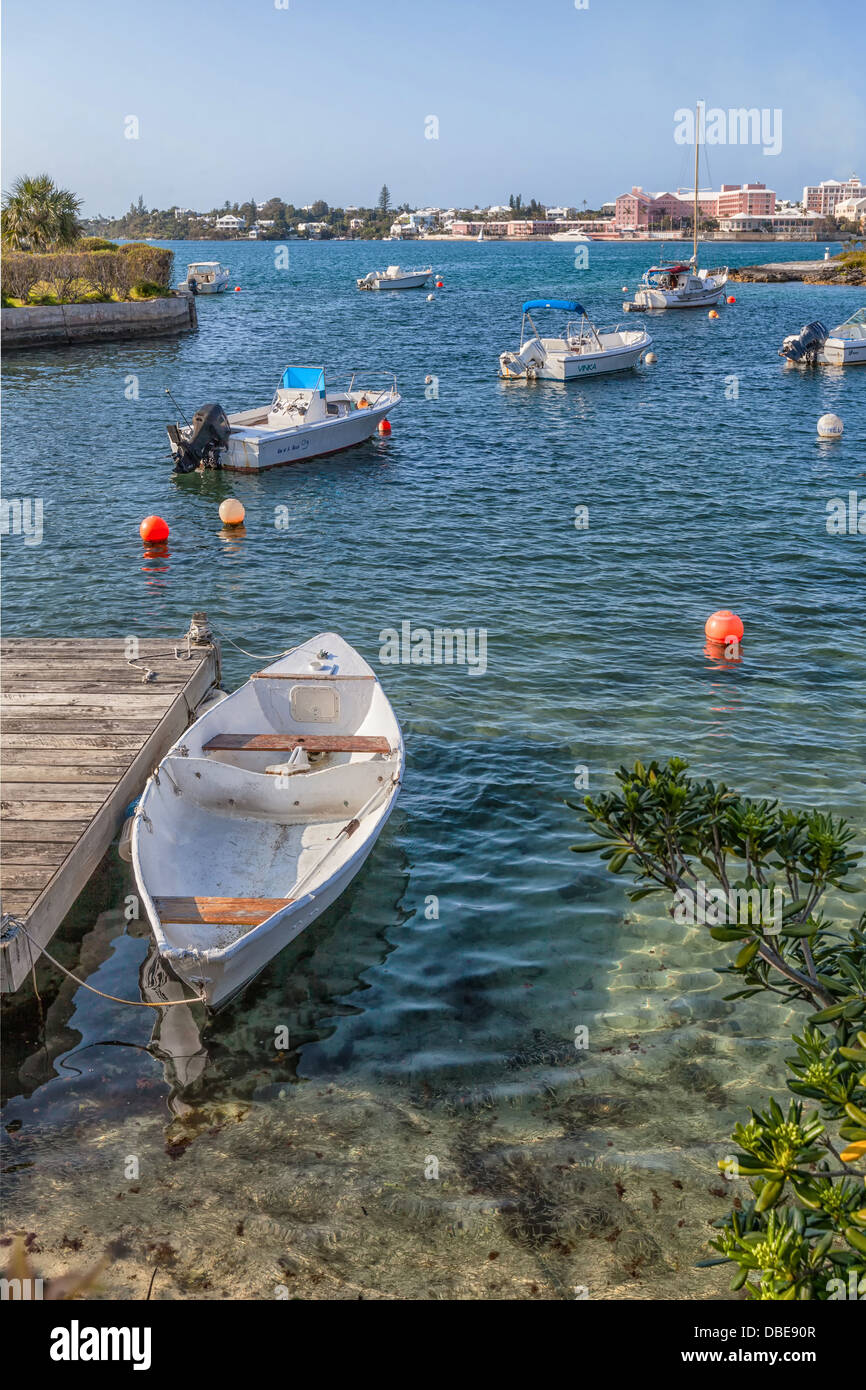 Embarcaciones de recreo amarrados a lo largo de las costas de Puerto Hamilton con la ciudad de Hamilton, Bermuda en la distancia. Foto de stock