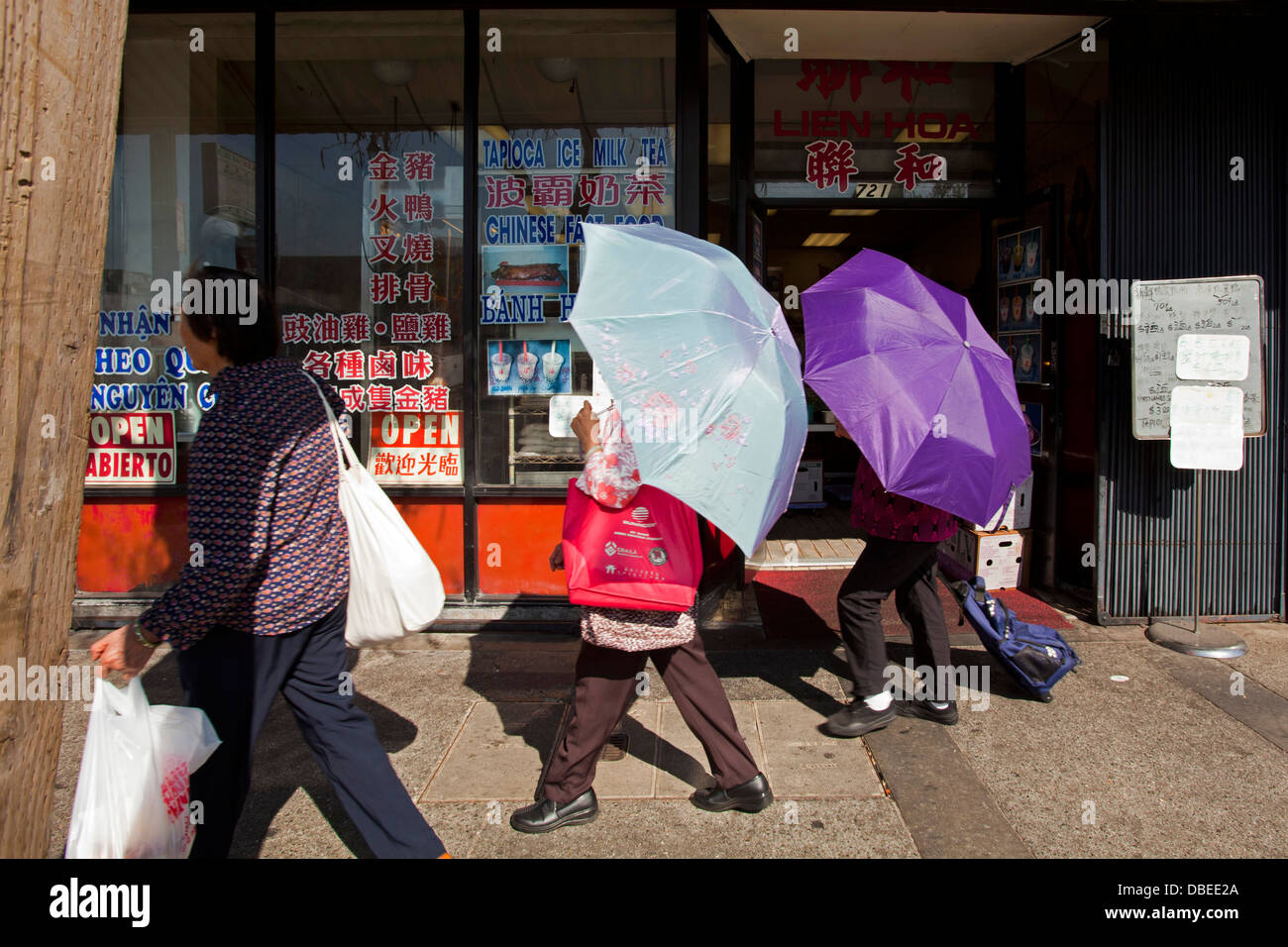 Batir el récord de calor en Chinatown. Las mujeres utilizan paraguas para la sombra. Los Angeles, California Foto de stock