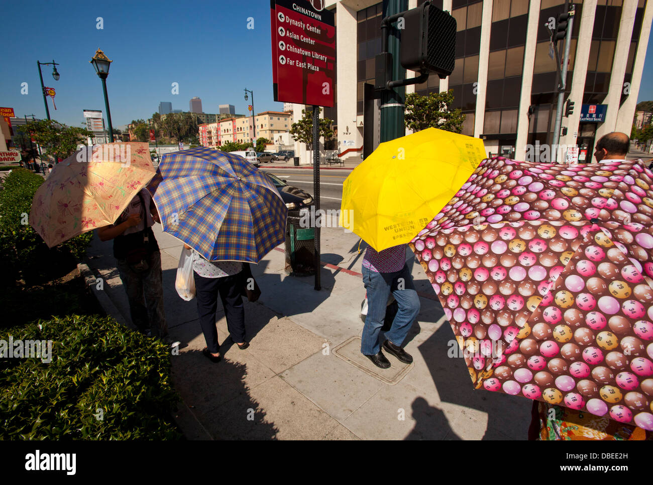 Batir el récord de calor en Chinatown. Las mujeres utilizan paraguas para la sombra. Los Angeles, California Foto de stock
