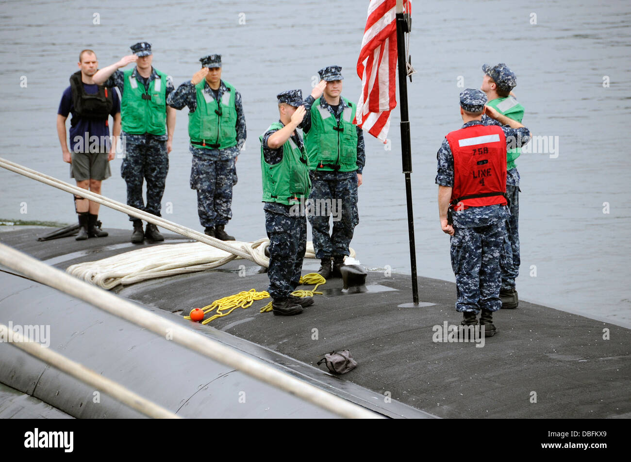 Los miembros de la tripulación del submarino de ataque rápido USS Ashville (SSN 758) hacen distinciones mientras cambia colores previa Ashville la llegada a Foto de stock