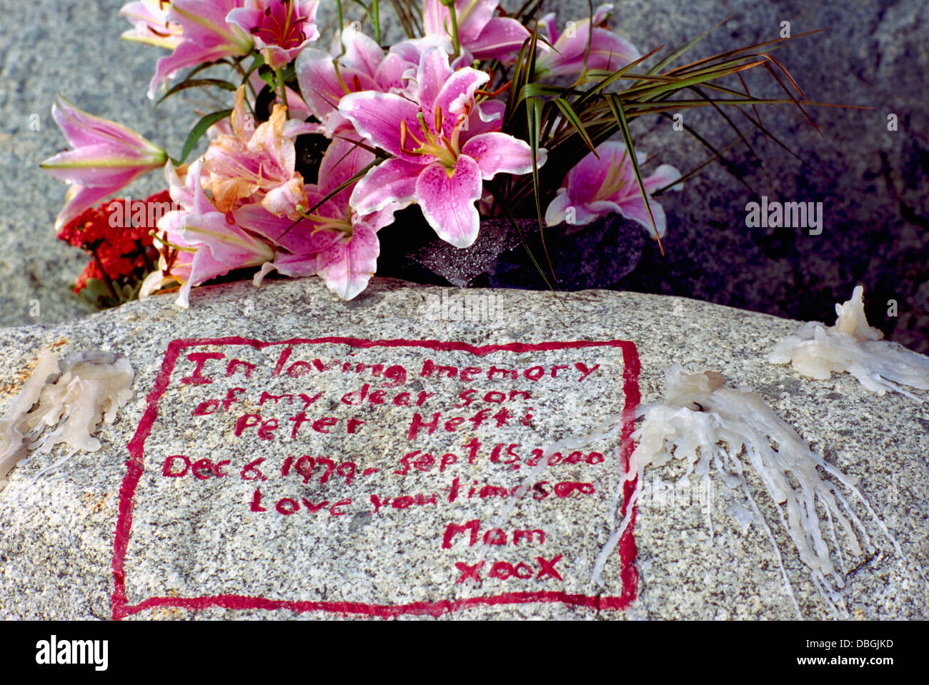 Flores y Memorial en memoria amorosa mensaje escrito en escritura roja  sobre roca, de luto la madre a su hijo muerto, Vigilia de velas Fotografía  de stock - Alamy