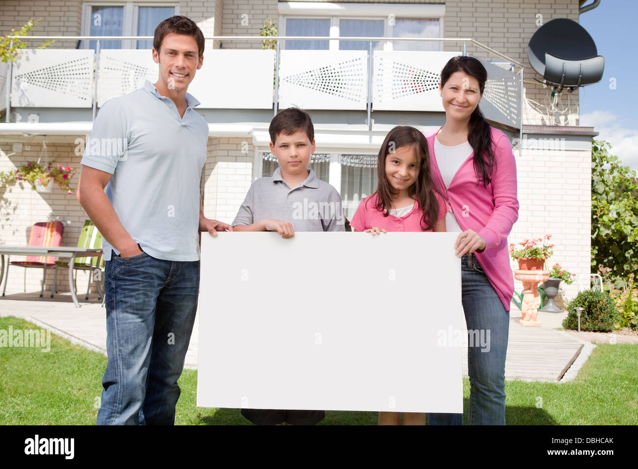 Familia Joven sosteniendo una placa en blanco y negro Foto de stock