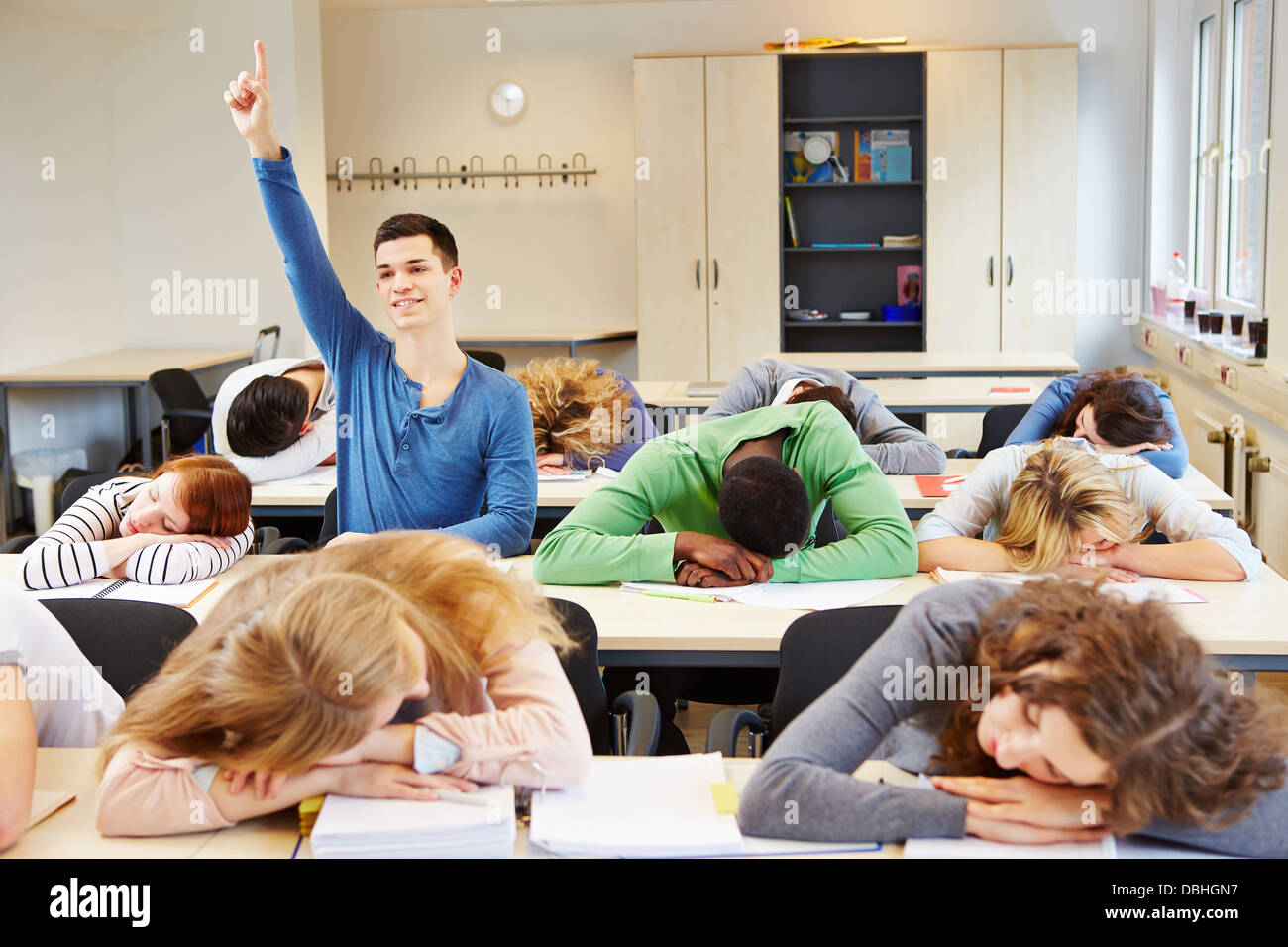 Estudiantes de dormir y diligente alumno en un aula Foto de stock