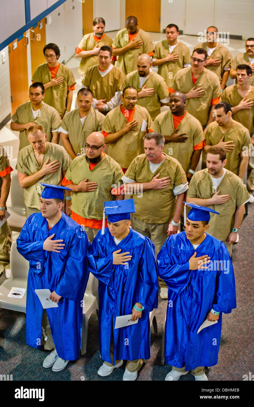 Vistiendo gorras y trajes académicos, tres reclusos se unieron sus compañeros presos multirracial en la prisión de la ciudad de Foto de stock