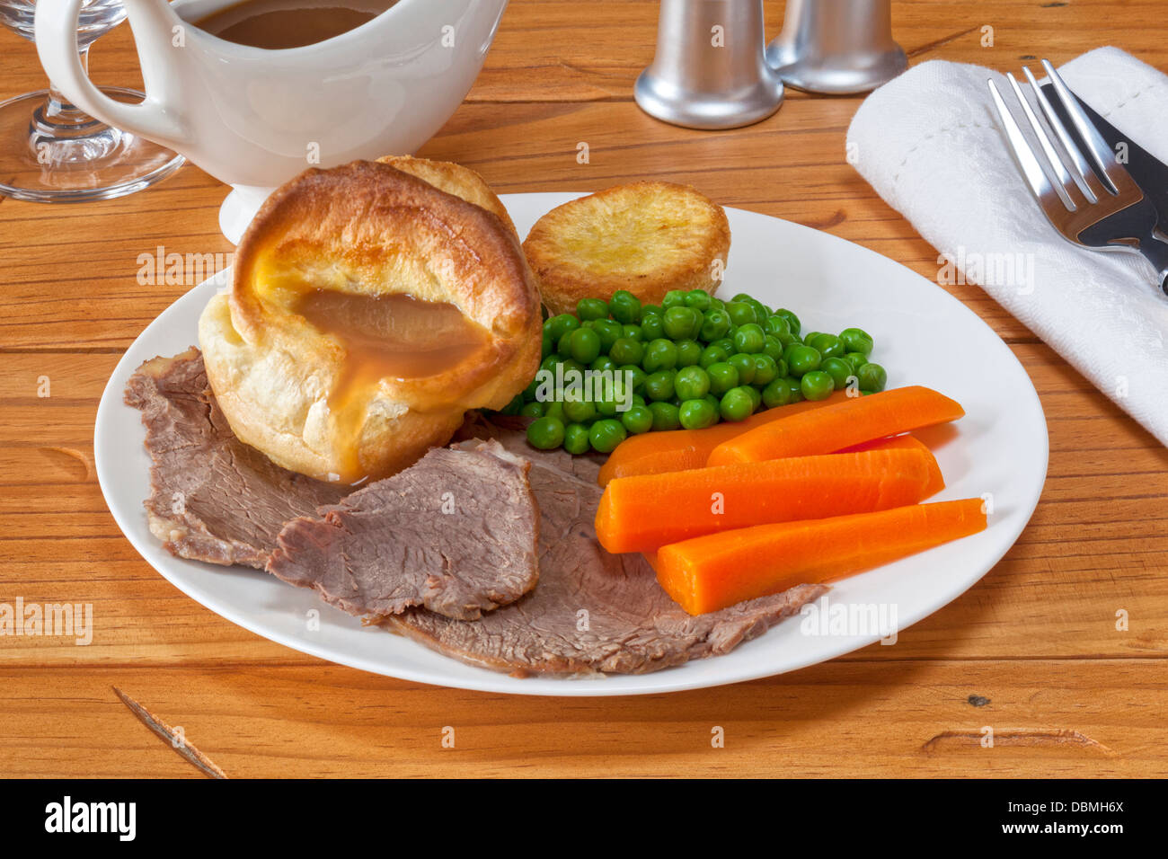 Roast Beef y Yorkshire pudding con salsa, patatas asadas, guisantes y