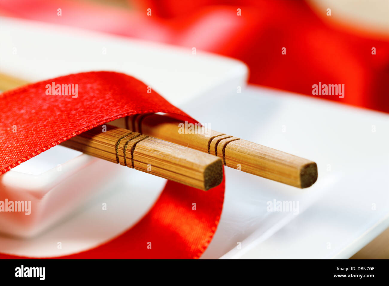 Los palillos y la cinta roja en una placa Foto de stock