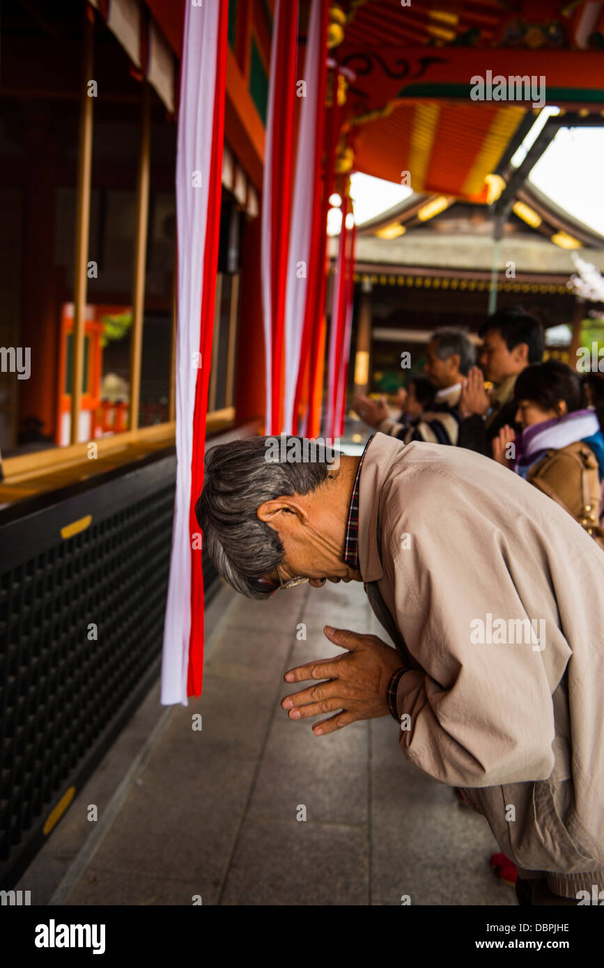 Orando peregrino en las interminables puertas rojo de Kioto de Fushimi Inari Shrine, Kyoto, Japón, Asia Foto de stock