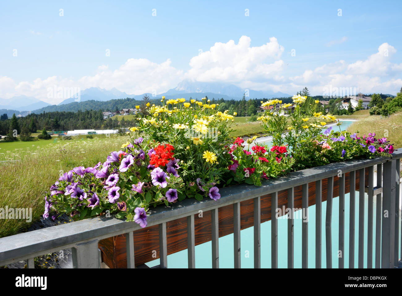 Cuadro de flores en un puente sobre el río Isar, en la aldea de Kruen en los Alpes de Baviera (Alemania) Foto de stock