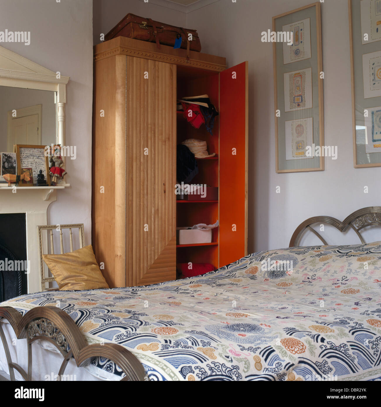 Armario ropero en la alcoba junto a la chimenea en dormitorio pequeño con  telas edredón de la cama de metal Fotografía de stock - Alamy