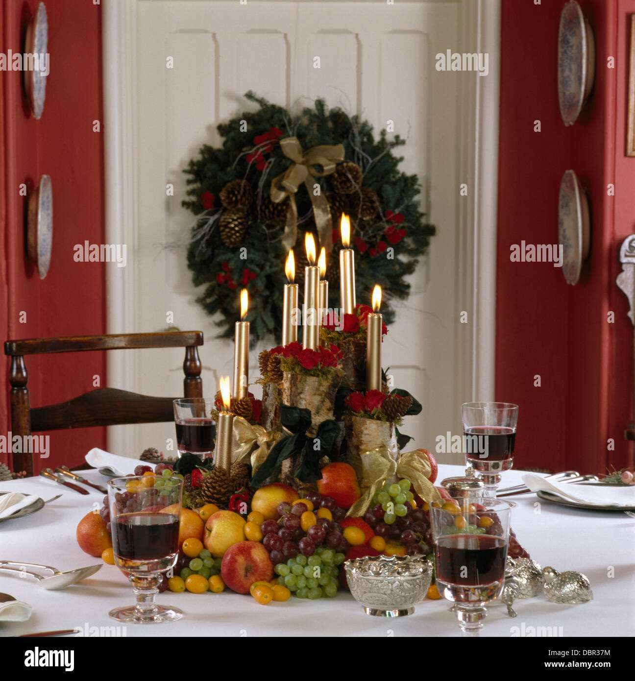 Cierre de oro iluminada velas en la decoración de frutas en mesa de comedor  para la cena de Navidad Fotografía de stock - Alamy