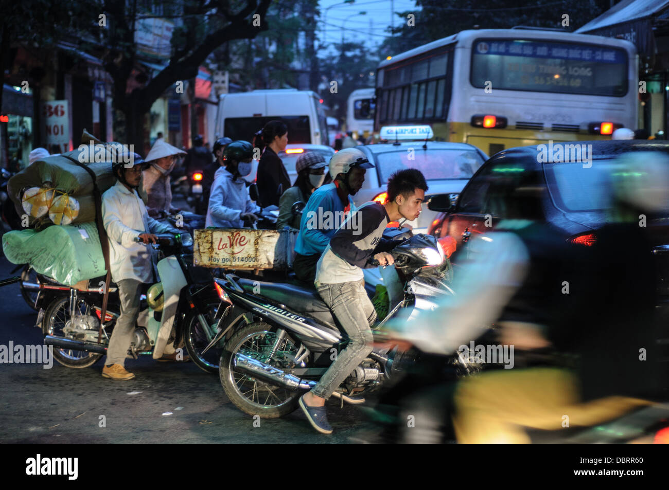HANOI, Vietnam - Gente en scooters negociar el agitado tráfico de Hanoi, el Casco Antiguo por la noche. Foto de stock