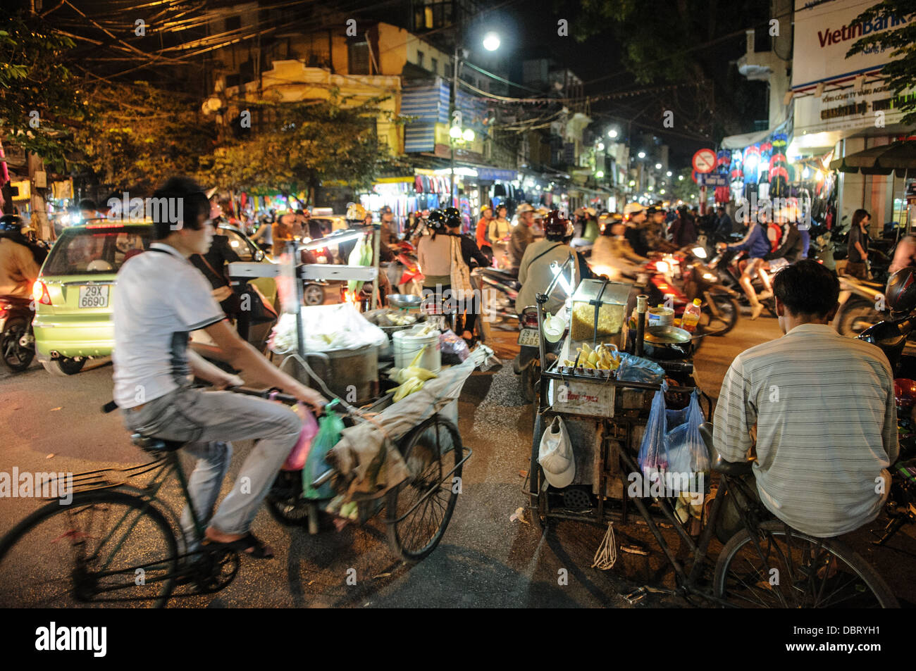 HANOI, Vietnam - tráfico concurrido en bicicletas y scooters en la noche en el barrio antiguo de Hanoi. Foto de stock