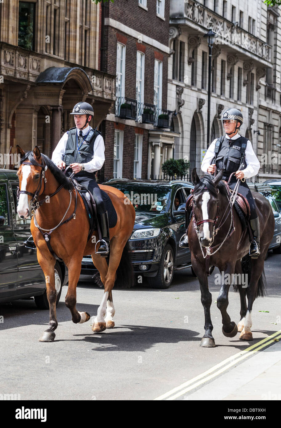 Dos funcionarios de la policía metropolitana británica montado en patrulla, Great George Street, Londres, Inglaterra, Reino Unido. Foto de stock