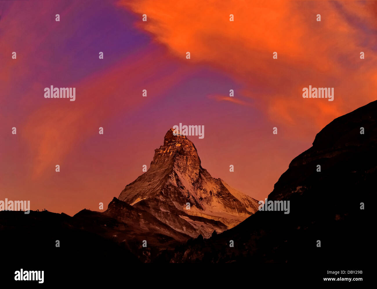 El Matterhorn justo antes del amanecer, las nubes reflejan los primeros rayos del sol. Foto de stock