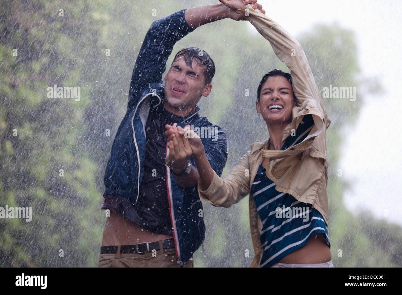 Feliz pareja bailando en la lluvia Foto de stock