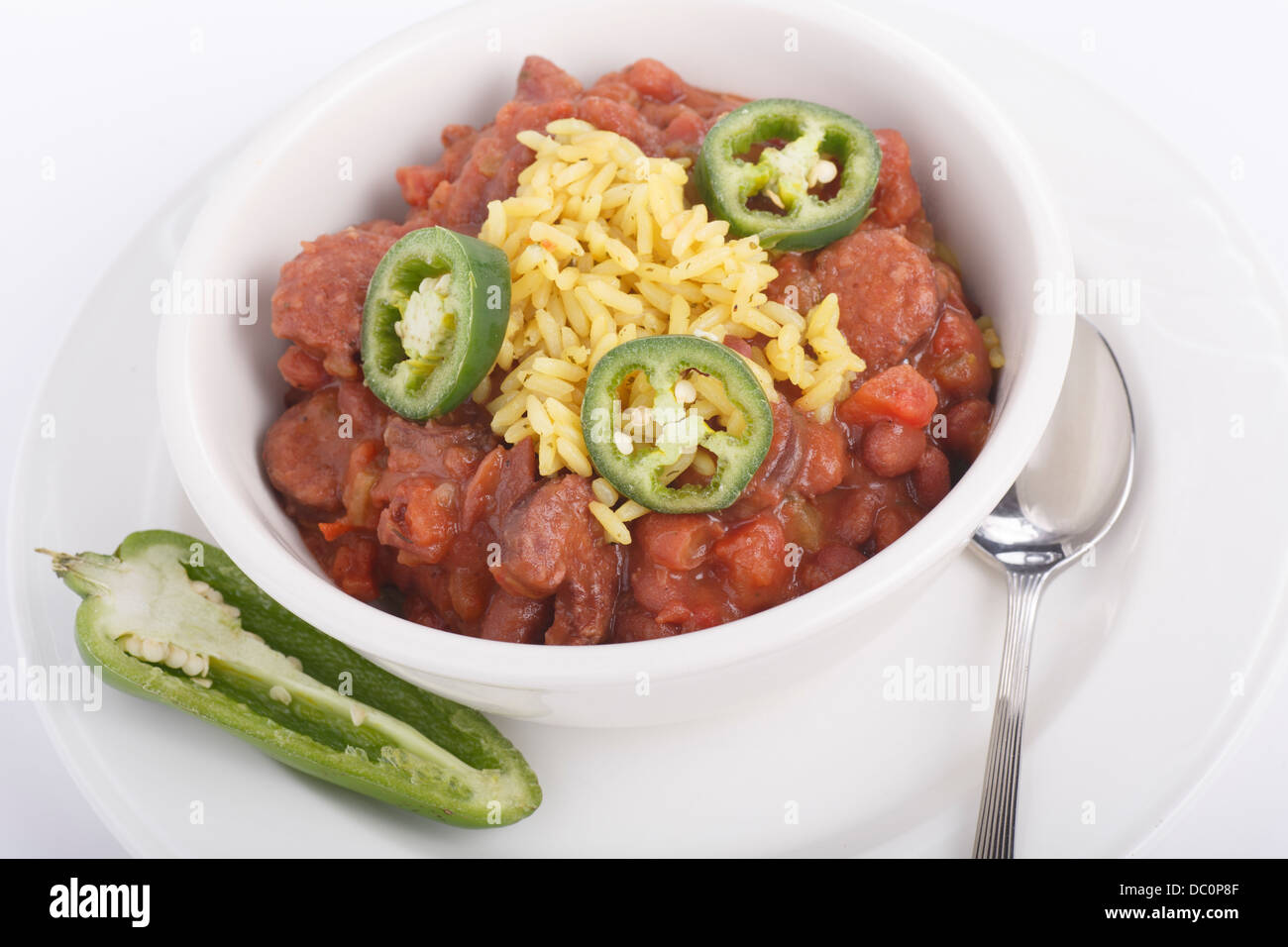 Un plato de frijoles rojos y arroz amarillo con corte chiles jalapeños Foto de stock