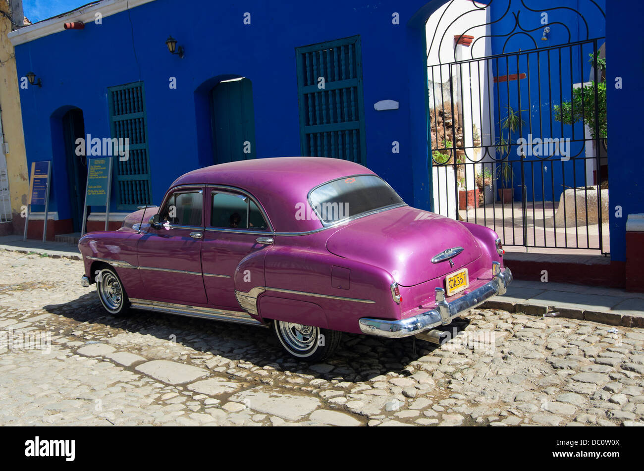 Púrpura brillante chevy estacionado en la parte frontal del edificio azul Foto de stock