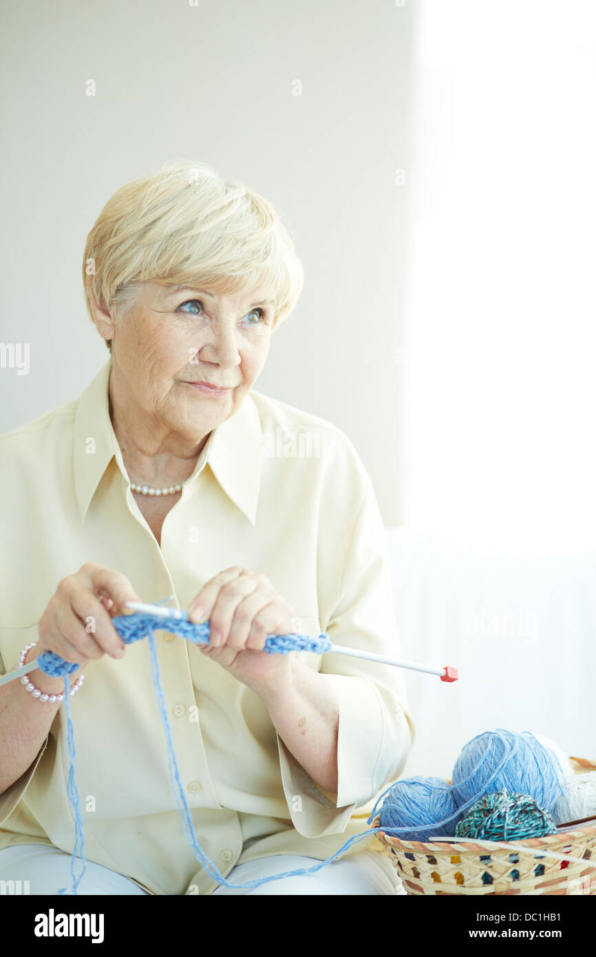Retrato de anciana tejiendo en casa Foto de stock
