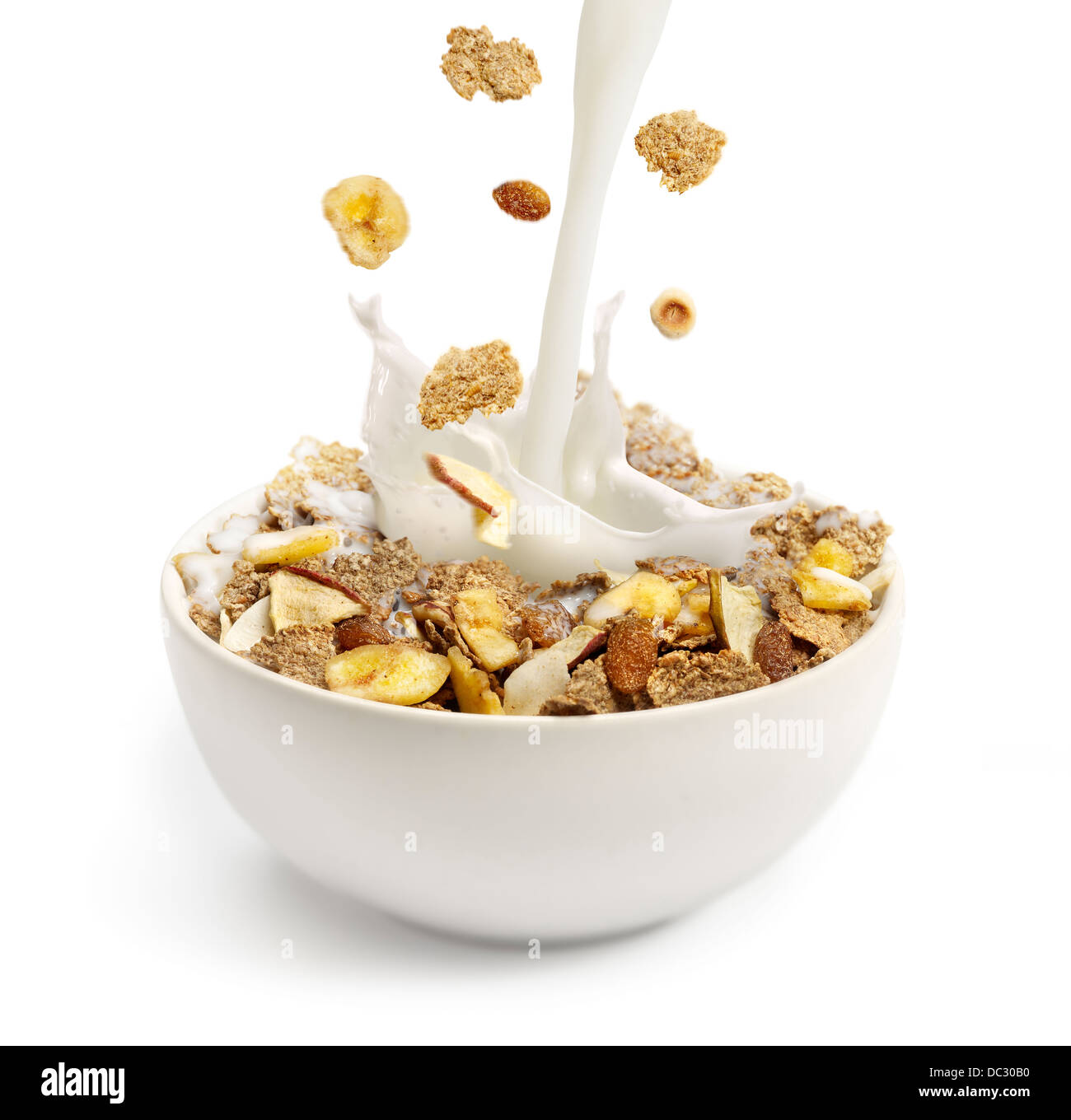 Verter la leche en un tazón de cereales para el desayuno Foto de stock