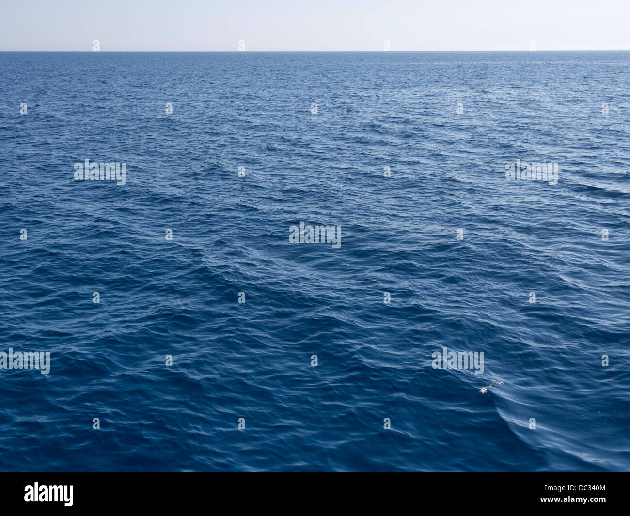 Mar azul claro con la línea lejana del horizonte Foto de stock