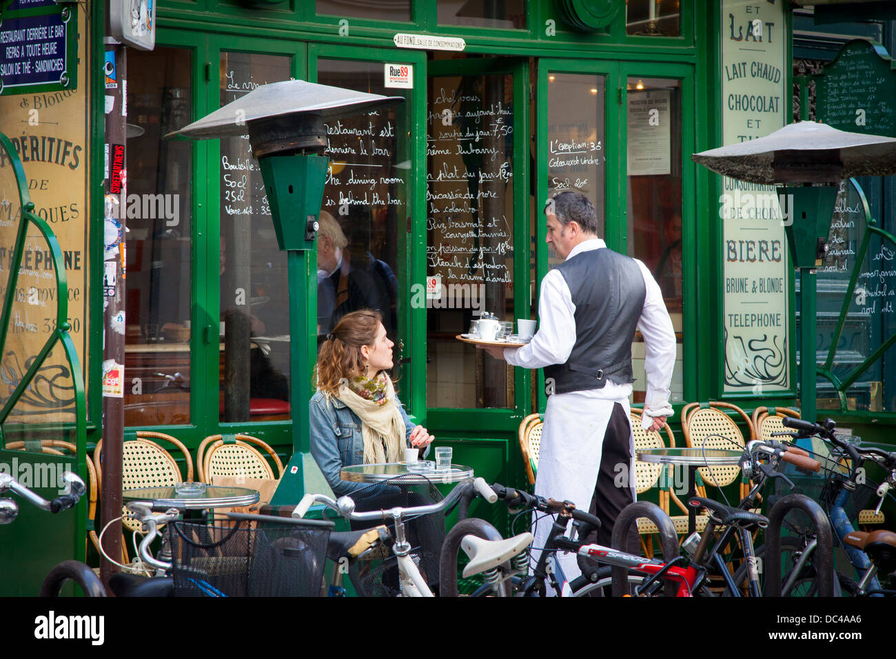 Camarero y cliente en un café en les Marais, París, Francia Foto de stock