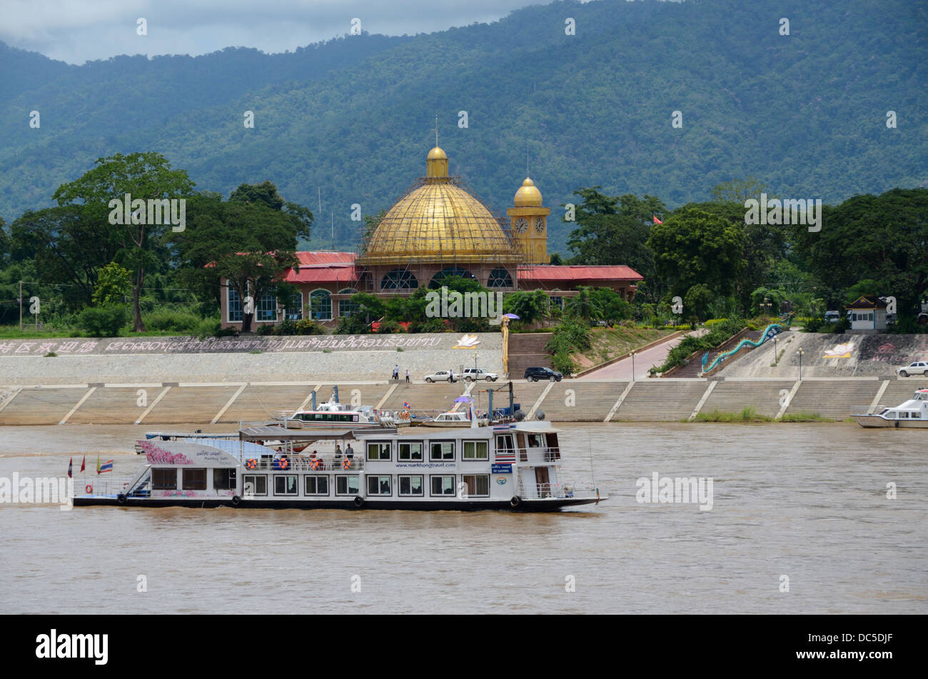 Barco de pasajeros entre Jinghong y Chiang Saen en río Mekong pasando un casino en Laos Foto de stock