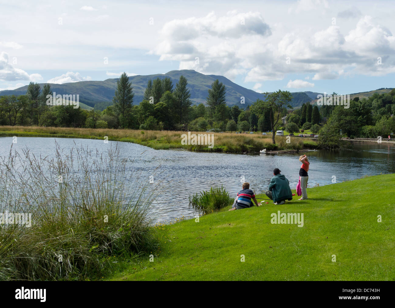 Pequeño grupo familiar relajante por el río Teith en Callander Perthshire Escocia Foto de stock