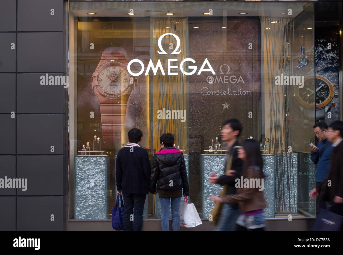 El pueblo chino de escaparates en Omega relojes de lujo tienda en Shanghai China Foto de stock