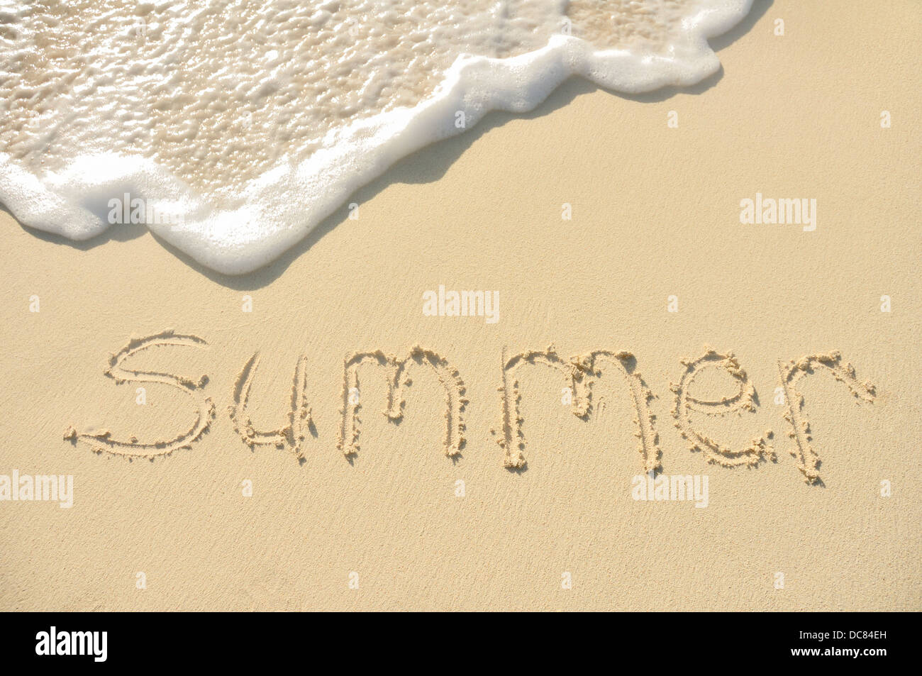 La palabra escrita en el verano en una playa de arena Foto de stock