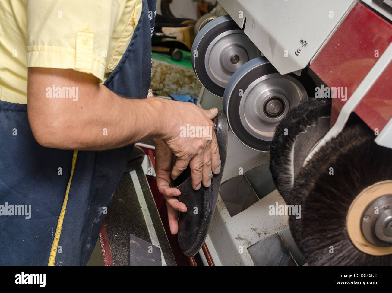 Un hombre pulir un zapato con la máquina Foto de stock