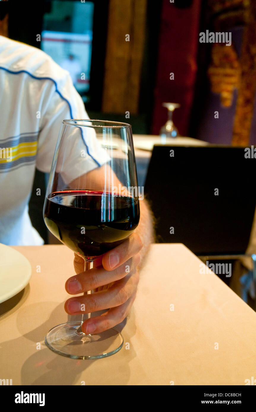 La mano del hombre con un vaso de vino tinto en un restaurante. Cerrar  vista Fotografía de stock - Alamy