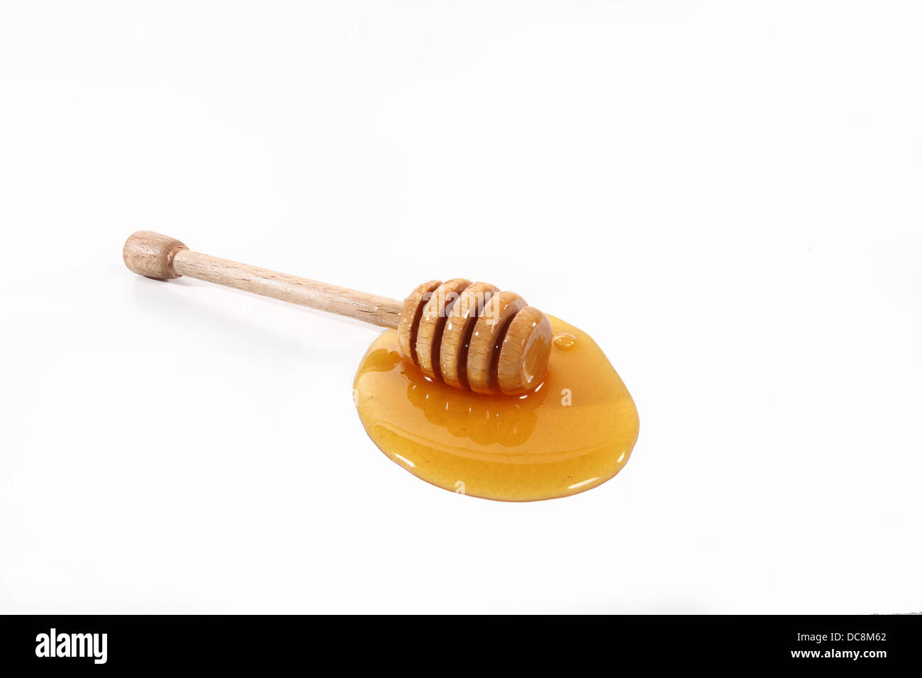 Cucharada de miel sobre fondo blanco. Foto de stock