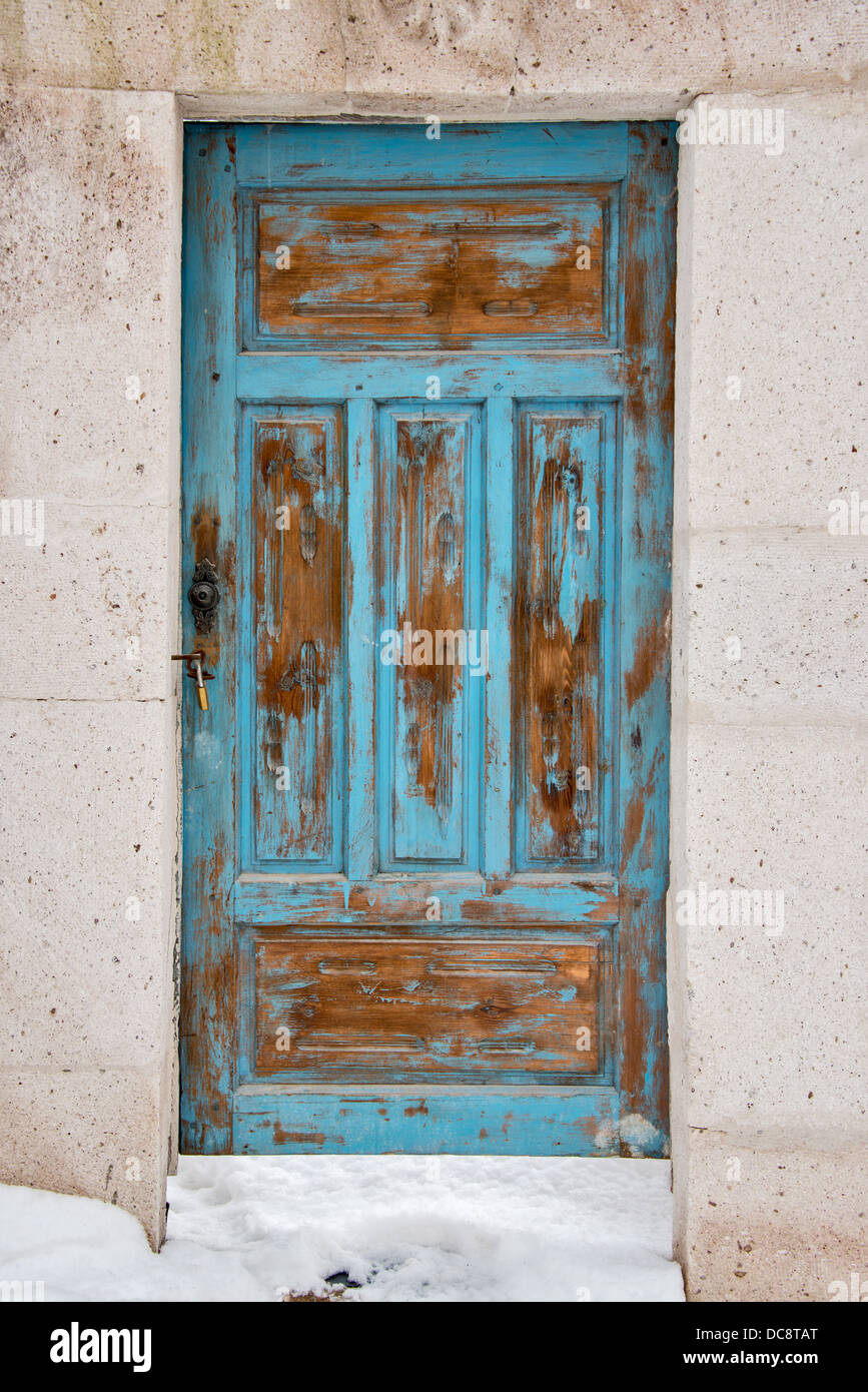 Antigua puerta azul en un pueblo nevado Foto de stock