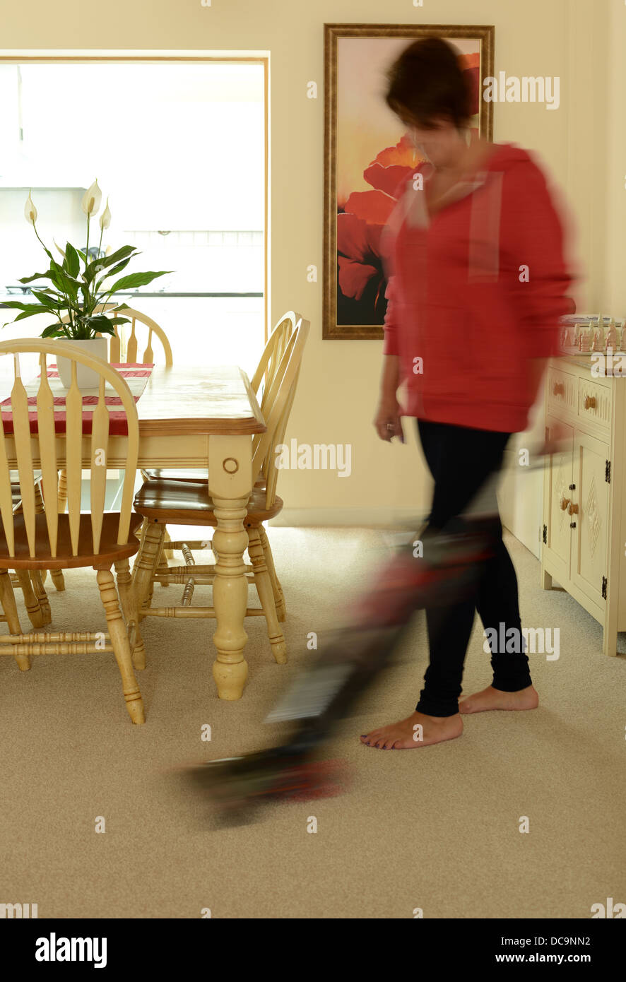 Mujer recopilación en casa con un aspirador. Foto de stock