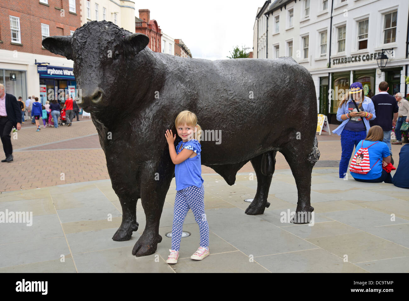 Niño por Hereford Bull estatua de bronce, High Street, Ciudad Alta, Hereford, Herefordshire, Inglaterra, Reino Unido Foto de stock