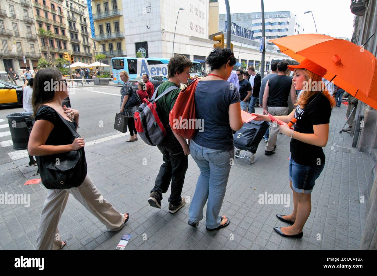 Chica con paraguas naranja distribuir publicidad. La calle Pelai.  Barcelona. Cataluña. España Fotografía de stock - Alamy