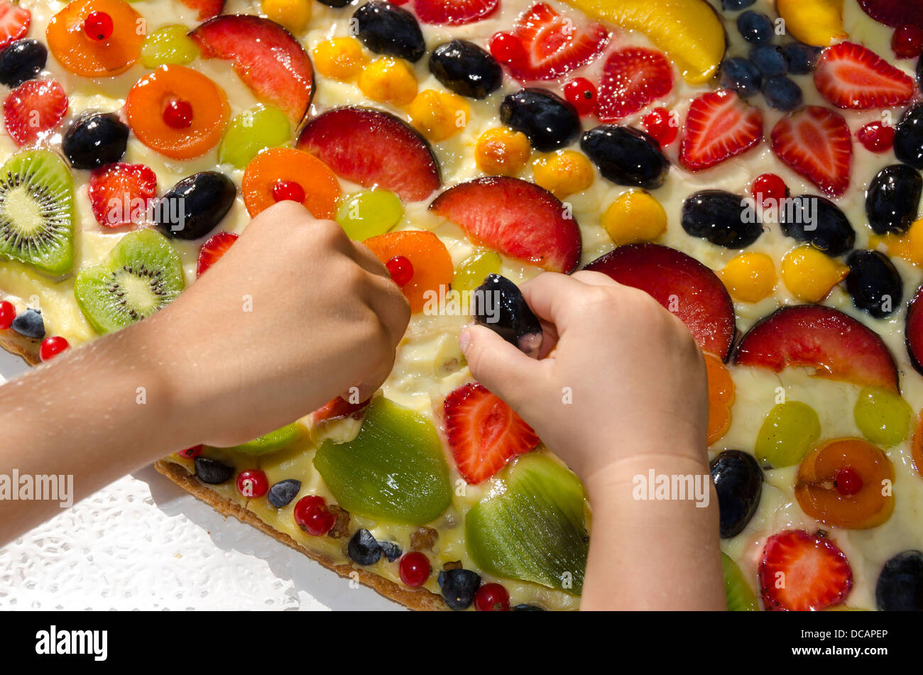 Los niños robar a un pastel de frutas Foto de stock