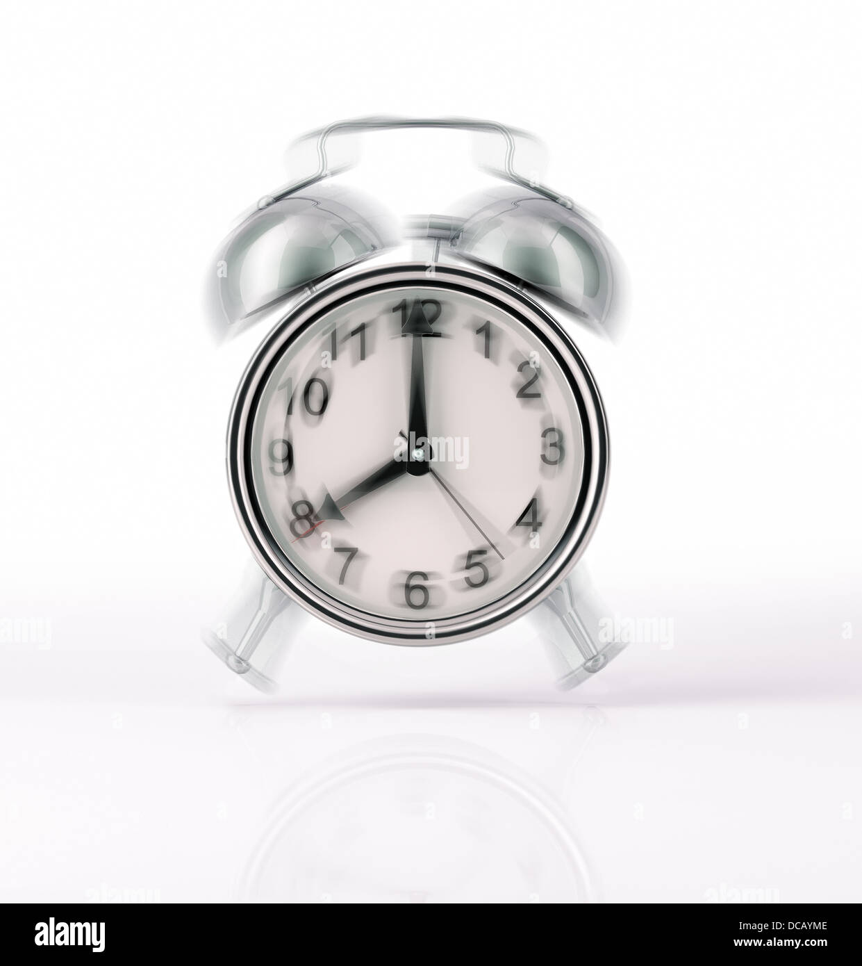 Reloj despertador clásico timbre cromado, con efecto de movimiento. Vista frontal sobre fondo blanco, con una ligera reflexión sobre la superficie Foto de stock