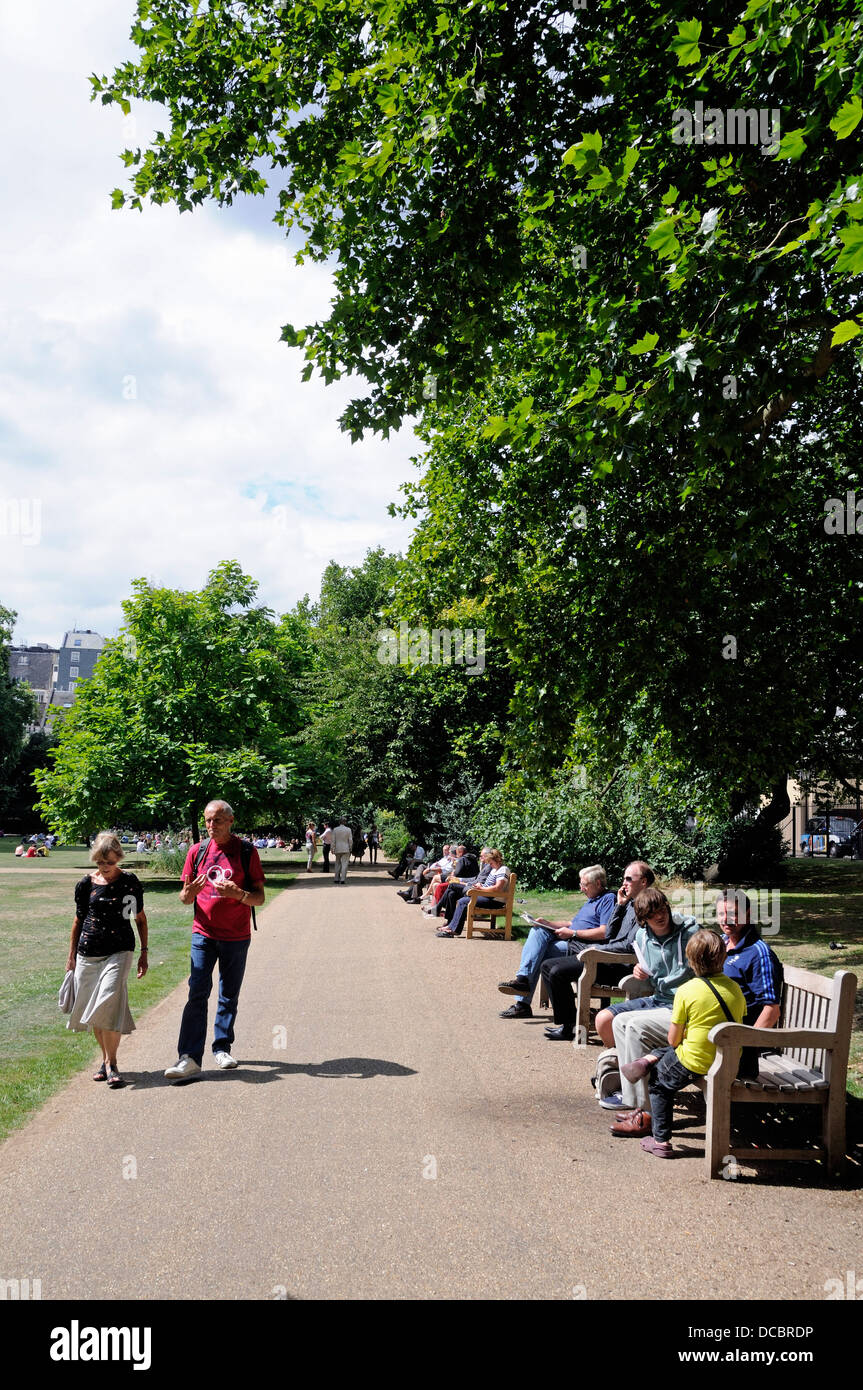 Campos de Lincoln's Inn Plaza pública con personas sentadas en los banquillos disfrutando del sol, Londres, Inglaterra Foto de stock