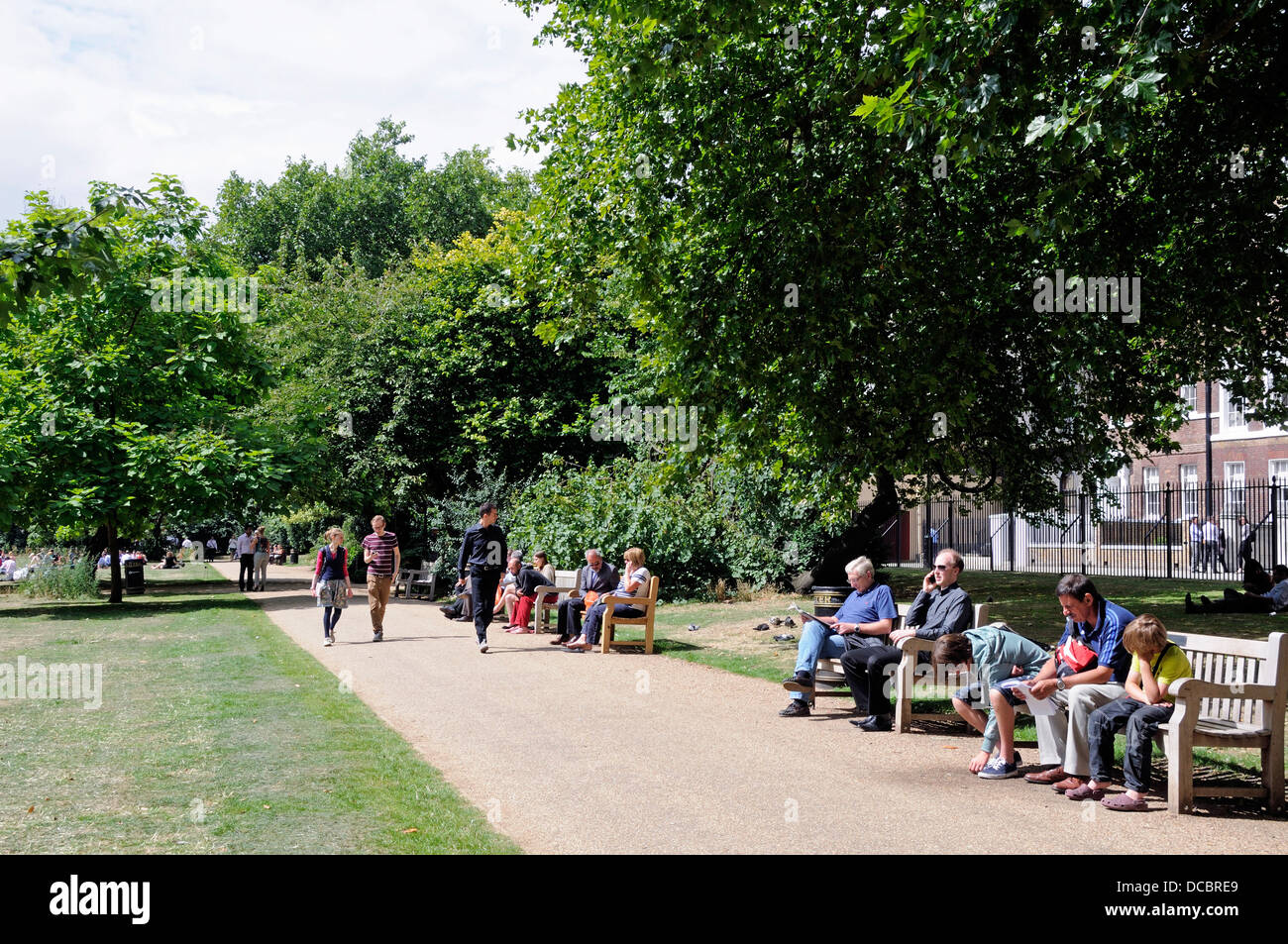 Campos de Lincoln's Inn Plaza pública con gente caminando por un sendero o sentados sobre bancos disfrutando del sol, Londres, Inglaterra Foto de stock