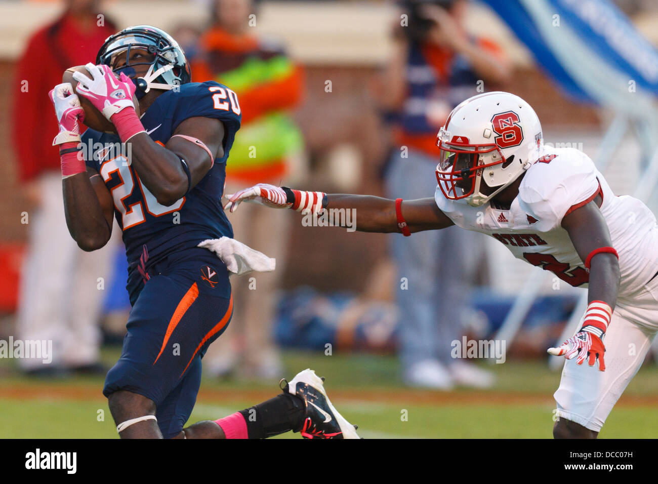 Virginia Cavaliers receptor ancho Tim Smith (20) coge el balón pasado North Carolina State Wolfpack receptor ancho Rashard Smith Foto de stock