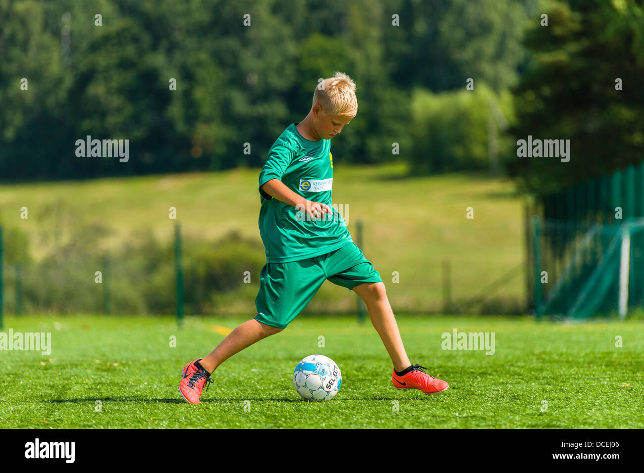 Joven futbolista hacer ejercicios en el campo de fútbol, día soleado Foto de stock