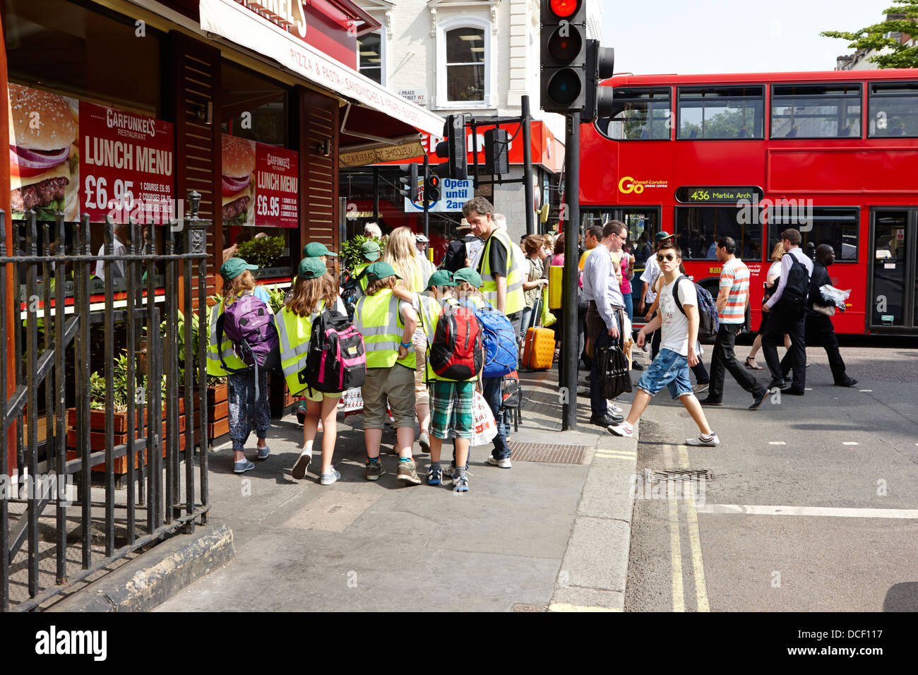 Los niños en la escuela de viaje a Londres vistiendo chalecos alta visibilidad Inglaterra Foto de stock